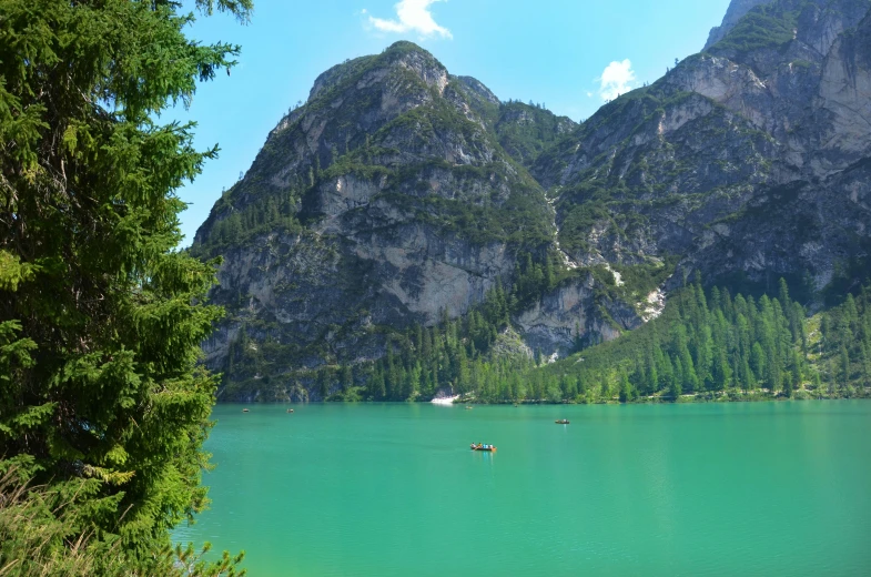 a large body of water with a mountain in the background, pexels contest winner, dolomites in background, avatar image, green water, gondolas