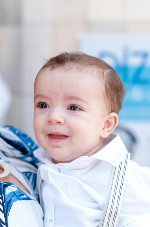 a woman holding a baby in her arms, by Nele Zirnite, pexels, portrait of benjamin netanyahu, detail shot, young boy, baptism