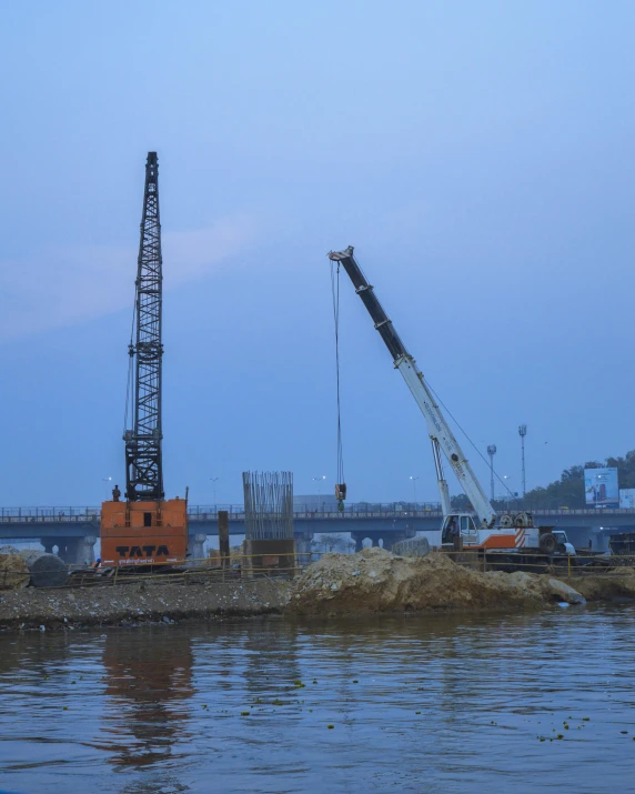 a crane sitting on top of a body of water, concrete, digging, guwahati, profile image