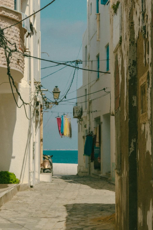 a narrow alley with clothes hanging out to dry, unsplash contest winner, renaissance, view of the ocean, apulia, cables and wires, profile image