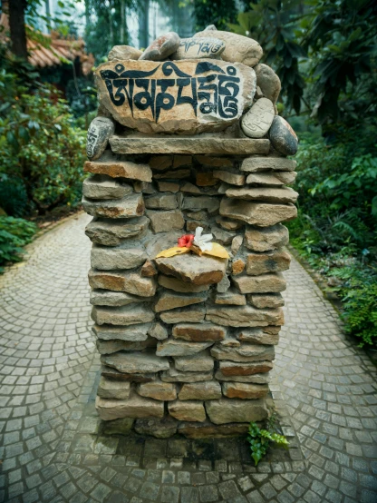 a stone pillar with a sign on top of it, by Muggur, health spa and meditation center, botanic garden, tibetan book of the dead, foot path