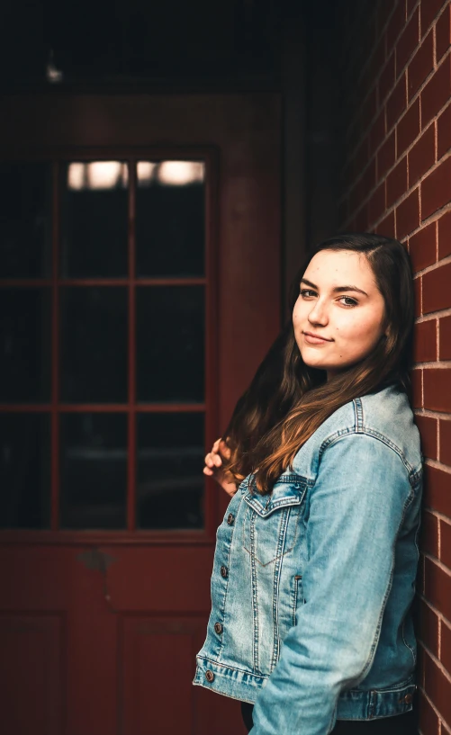 a young woman leaning against a brick wall, by Grace Polit, unsplash, dslr photo of a pretty teen girl, 15081959 21121991 01012000 4k, plain background, lights on