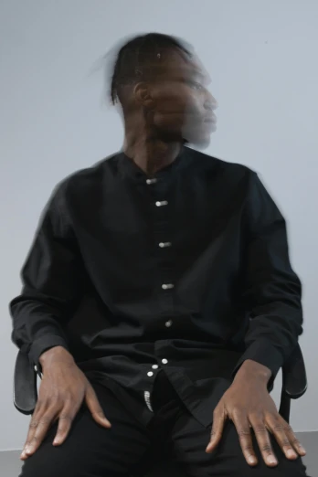 a man in a black shirt sitting in a chair, inspired by Feng Zhu, unsplash, conceptual art, cropped shirt with jacket, david uzochukwu, 3/4 front view, round-cropped