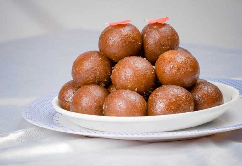 a close up of a plate of doughnuts on a table, pochi iida, bells, medium, square