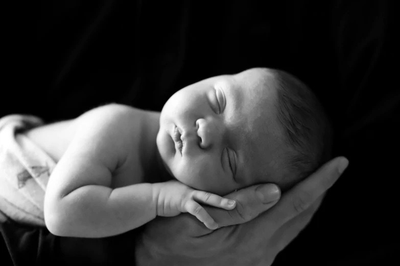 a close up of a person holding a baby, a black and white photo, by Caroline Mytinger, pexels, asleep, professional studio photography, peaceful face, various posed