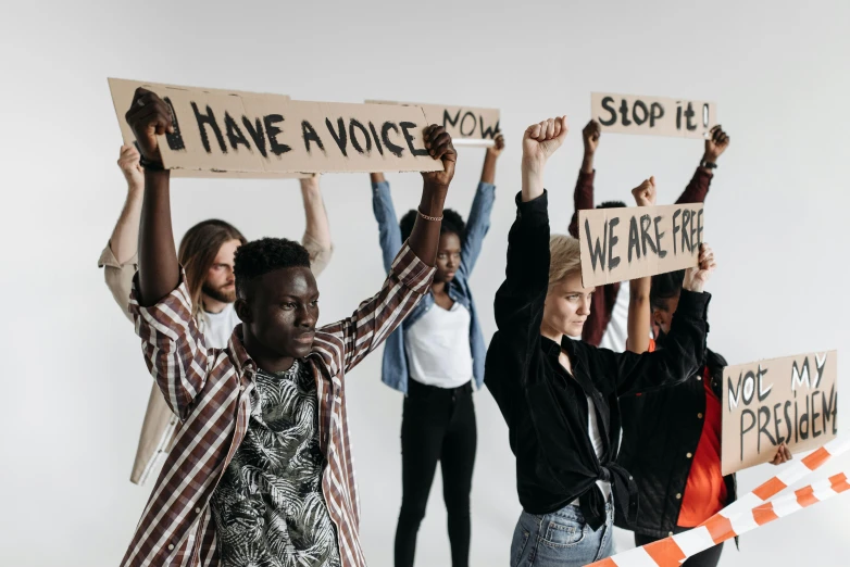 a group of people holding up signs, by Matija Jama, trending on pexels, bravery, background image, humanization, an ultra realistic