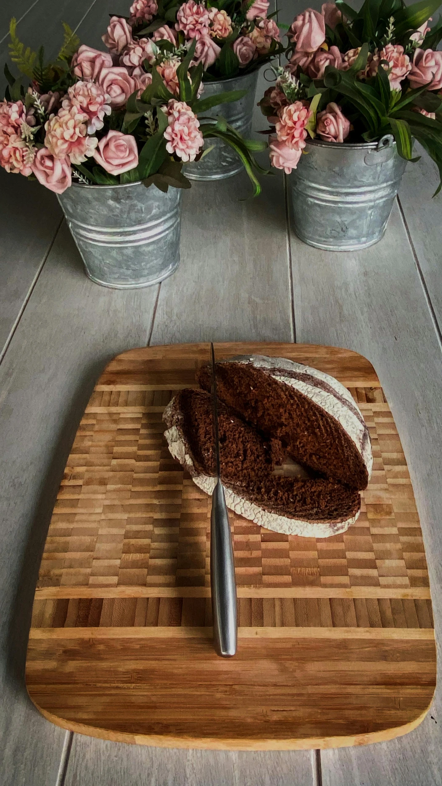 a piece of bread sitting on top of a cutting board, inspired by Richmond Barthé, cyber copper spiral decorations, brown:-2, beautiful aged and rustic finish, holding a kitchen knife