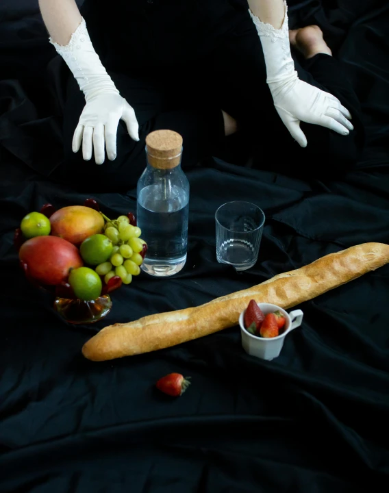 a woman in white gloves sitting on a black cloth, a still life, unsplash, holding a baguette, strange fruits, transhumanist hydration, ignant