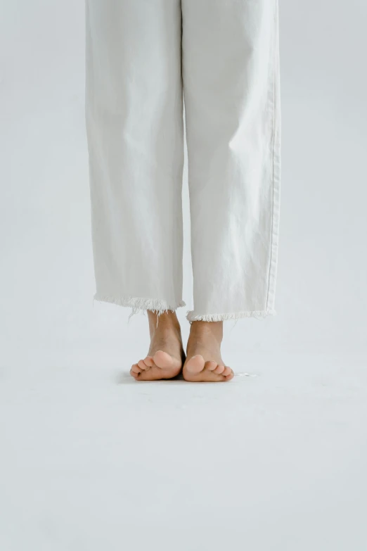 a person standing in front of a white background, by Kim Tschang Yeul, trending on pexels, barefoot, wearing ragged clothing, white pants, slippers