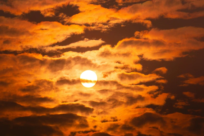 the sun is shining through the clouds in the sky, by Matt Cavotta, pexels, romanticism, an orange fire in the background, big red sun, patches of yellow sky, hot and humid