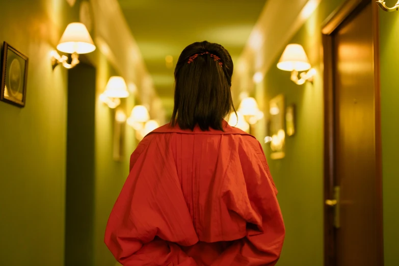 a woman standing in a hallway with her back to the camera, inspired by Satoshi Kon, pexels contest winner, red robe, hotel room, bright colour, girl wearing uniform