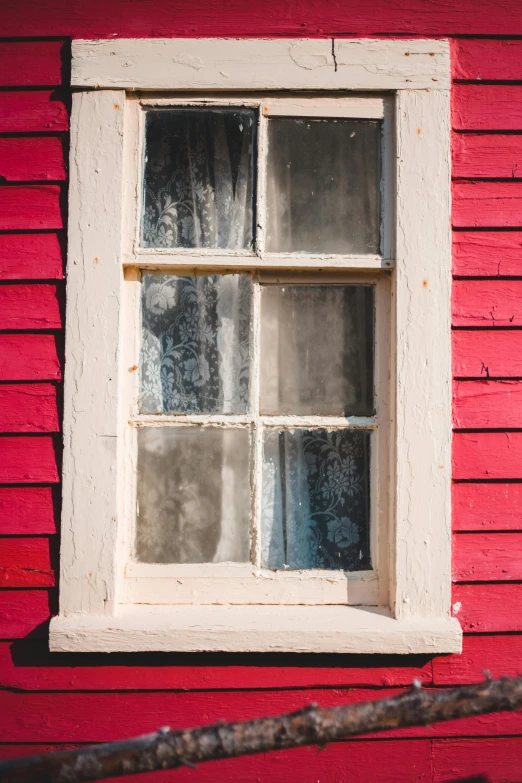 a close up of a window on a red building, inspired by Michael Ancher, pexels contest winner, preserved historical, square, white plank siding, front lit