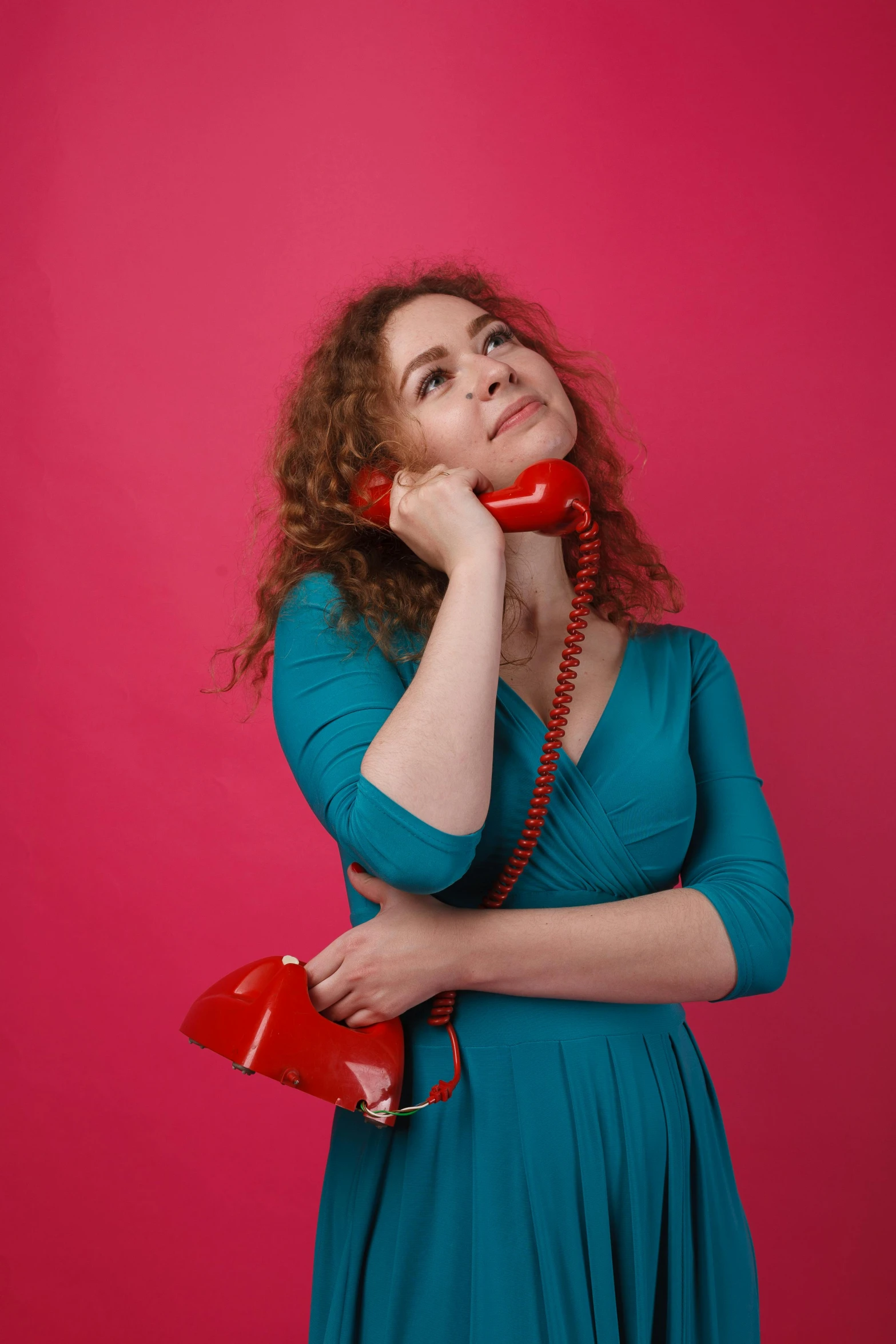 a woman in a blue dress talking on a red phone, pexels contest winner, curly haired, plain background, square, soviet style