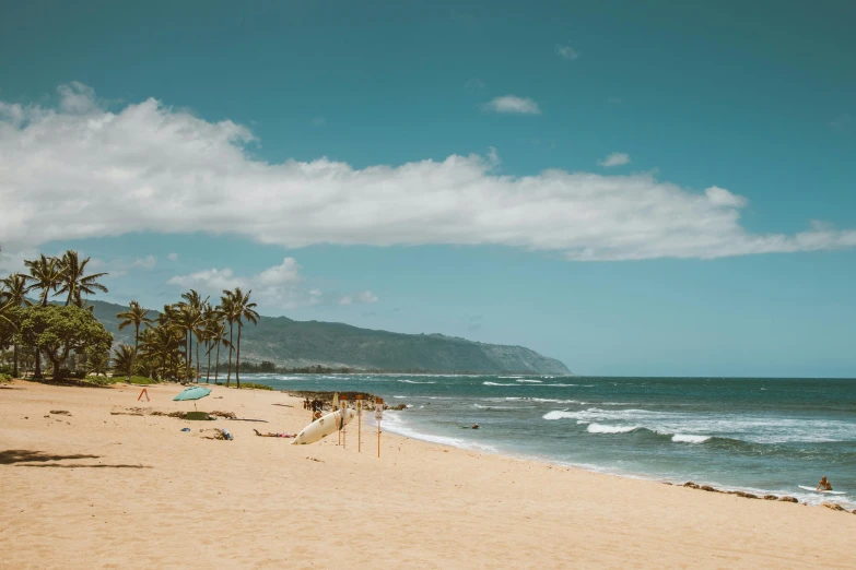 a group of people sitting on top of a sandy beach, lush, hawaii beach, unsplash photography, beach is between the two valleys