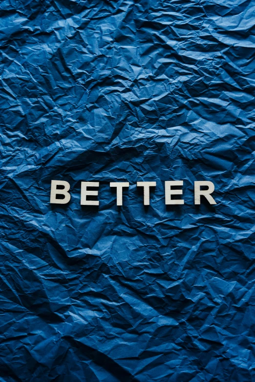 a blue crumpled paper with the word better written on it, an album cover, profile image, peter xiao, navy, plain background
