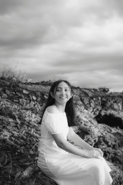 a woman in a white dress sitting on a rock, a black and white photo, inspired by Tang Yifen, unsplash, smiling girl, aged 13, in volcano, ((portrait))