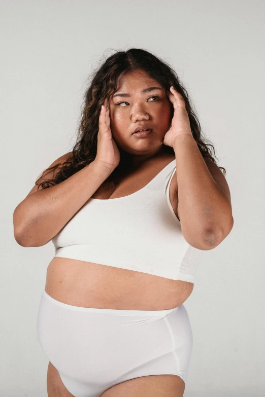 a woman in a white underwear posing for a picture, inspired by Kim Tschang Yeul, trending on pexels, curvaceous. detailed expression, wearing a cropped top, woman very tired, health supporter