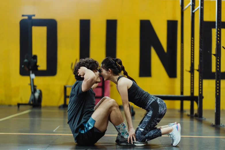 a couple of people sitting on top of a gym floor, by Nina Hamnett, hurufiyya, black and yellow scheme, athletic crossfit build, jin shan, profile image