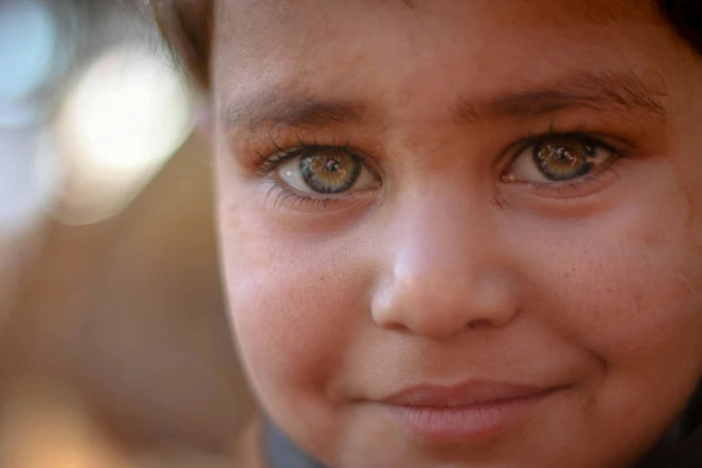 a close up of a child looking at the camera, hurufiyya, eyes open, portrait of bedouin d&d, olive skin color, medium-shot