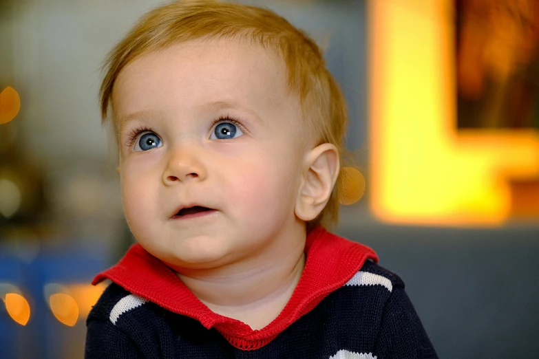 a close up of a child with blue eyes, pexels, light stubble with red shirt, thumbnail, toddler, looking to the side