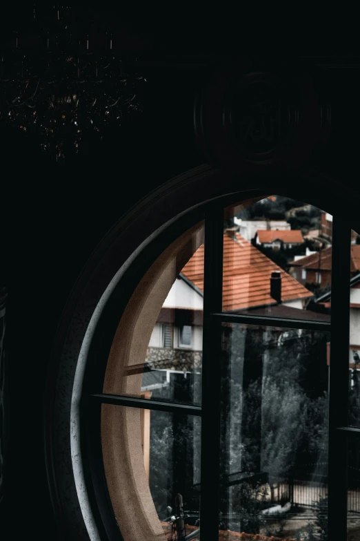 a close up of a window with a building in the background, round shapes, in an attic, dark academia aesthetics, swiss architecture