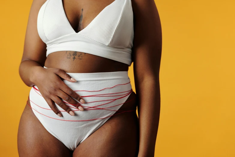 a woman in a white bikini posing for a picture, by Matija Jama, trending on pexels, figuration libre, red wires wrap around, diaper-shaped, thick black lines, shaquille o'neil pregnant