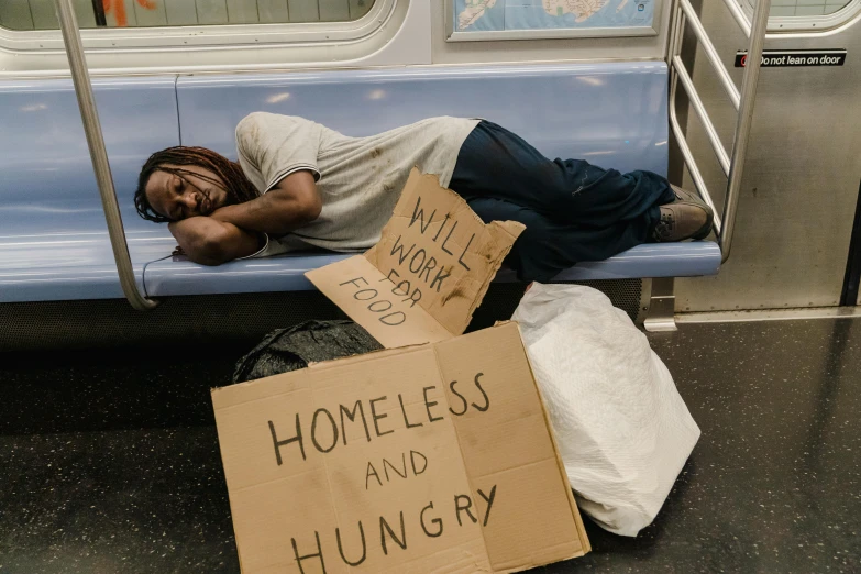 a homeless man sleeps on a subway bench, pexels contest winner, graffiti, woman holding sign, tins of food on the floor, photo of a black woman, 15081959 21121991 01012000 4k