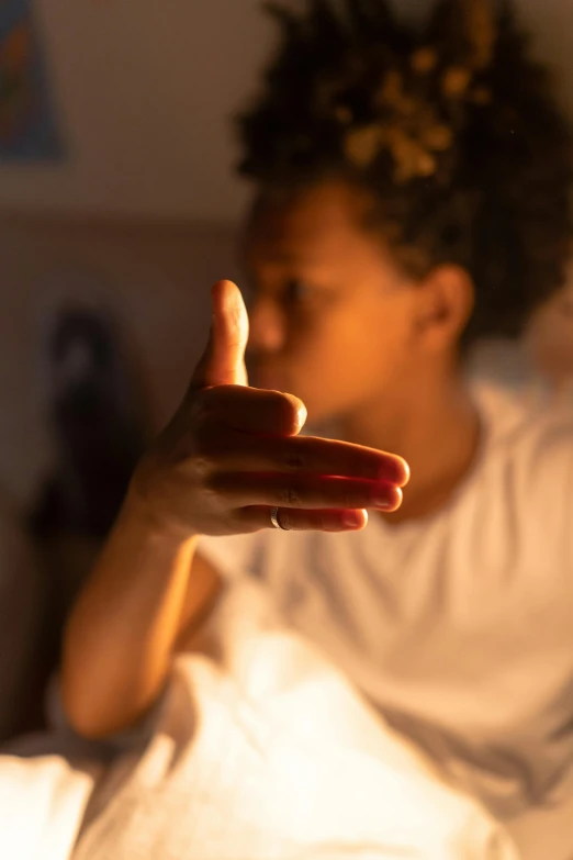 a woman sitting in bed with a cell phone in her hand, by Daniel Seghers, pexels contest winner, glowing fingers, black teenage boy, red cloud light, offering the viewer a pill