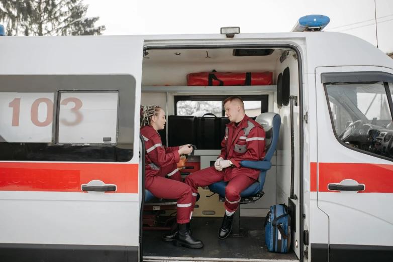 a couple of men sitting inside of an ambulance, by Adam Marczyński, pexels, hurufiyya, avatar image, young female firefighter, fully body photo, profile image