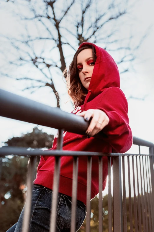 a woman in a red hoodie leaning on a railing, pexels contest winner, menacing pose, highly upvoted, hoody, avatar image