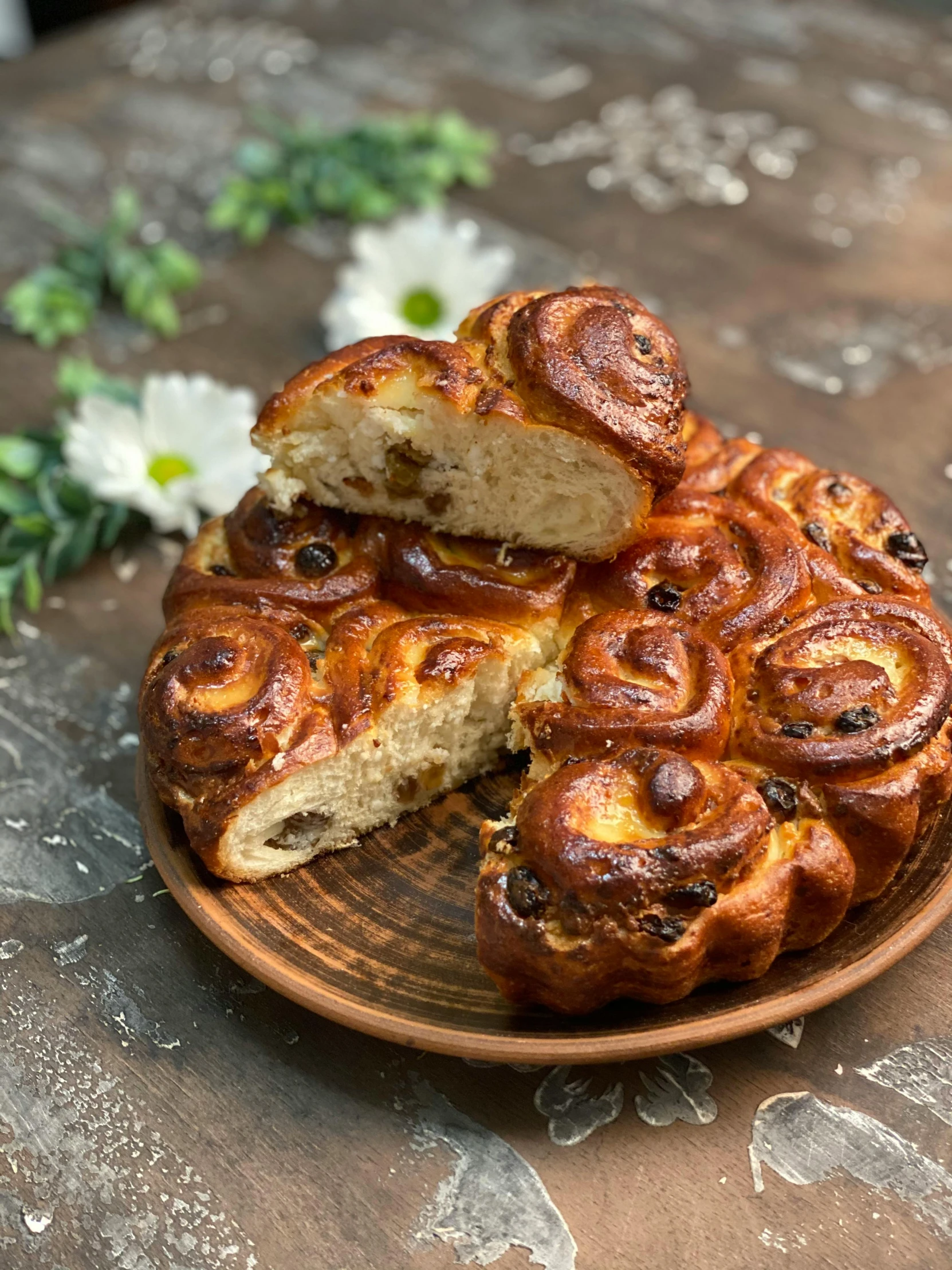 a close up of a plate of food on a table, inspired by Károly Markó the Elder, hurufiyya, in the shape of a cinnamon roll, the flower crown, style blend of the vatican, loaves