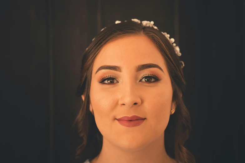 a close up of a woman with a flower in her hair, a colorized photo, inspired by Emma Ríos, unsplash, ivory make up on the eyes, formal portrait, wedding, thick eyebrows