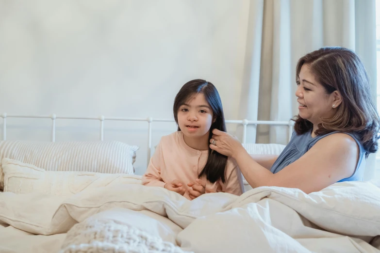 a woman combing a little girl's hair on a bed, inspired by Ruth Jên, pexels contest winner, hurufiyya, wearing nanotech honeycomb robe, avatar image, hand on cheek, asian woman