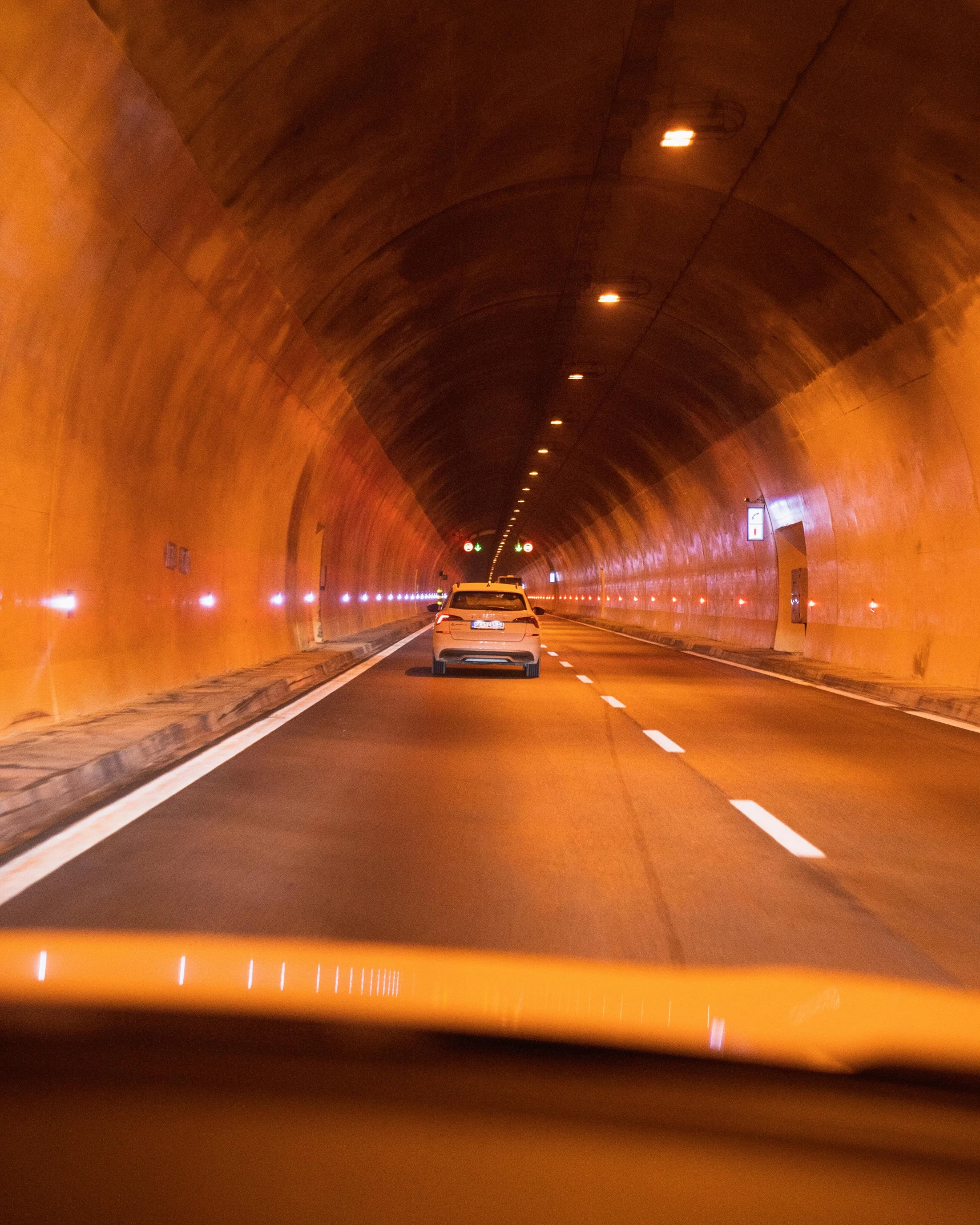 a car driving through a tunnel at night, by Julia Pishtar, pexels contest winner, terracotta, 🚿🗝📝, yellow light, inside a cavernous stomach