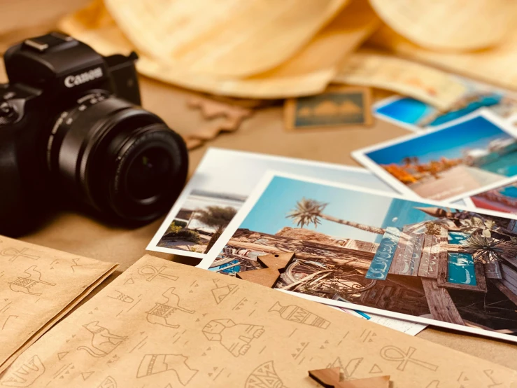 a camera sitting on top of a table next to pictures, a polaroid photo, pexels contest winner, from egypt, postage, vacation, conde nast traveler photo