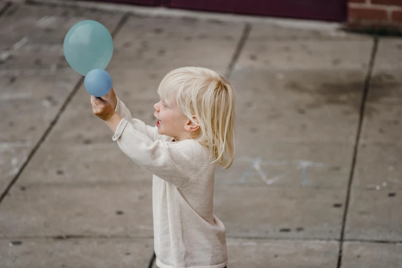 a little boy that is holding some balloons, by Nina Hamnett, pexels contest winner, magic realism, pale blue, play, street life, hammershøi