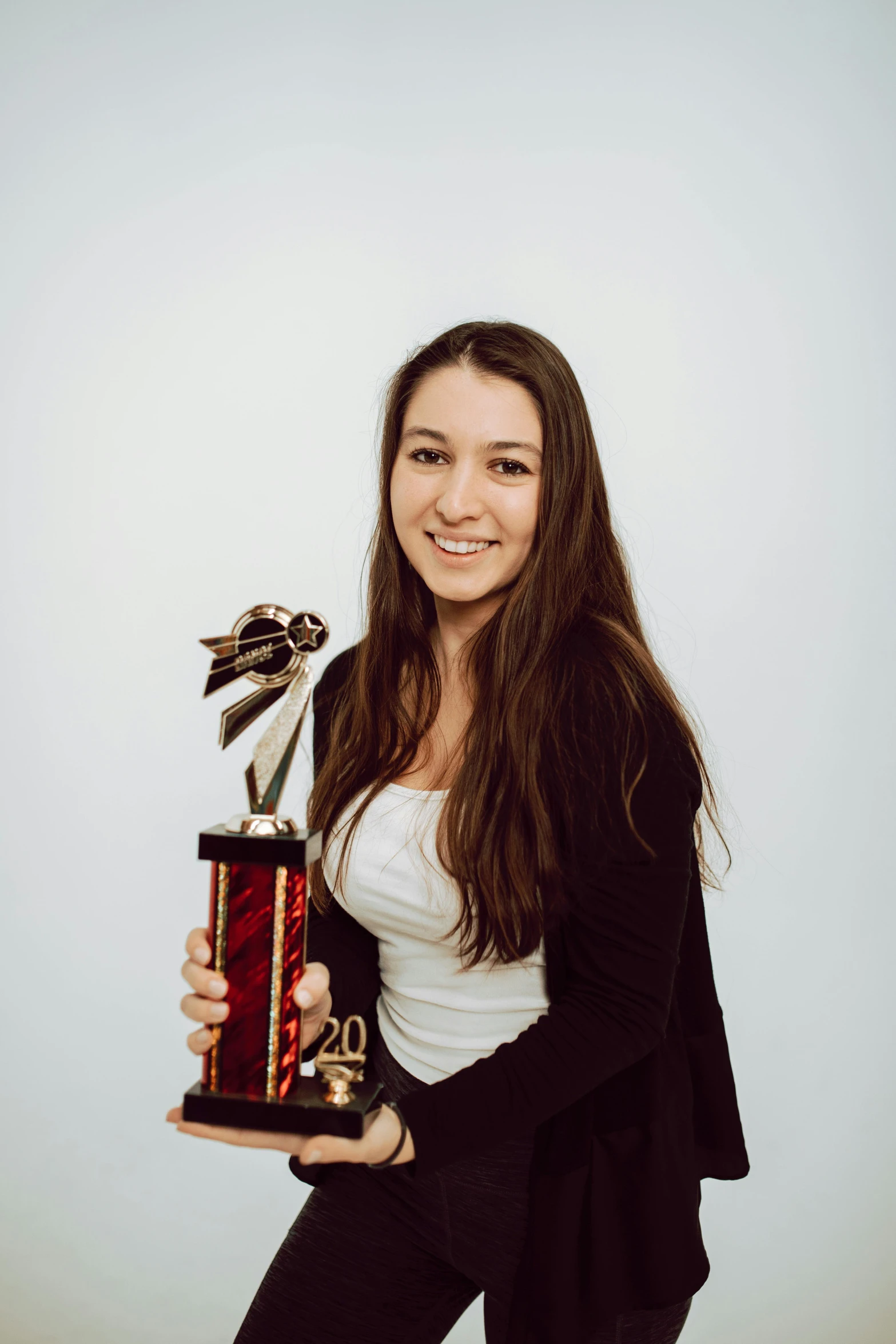 a woman holding a trophy and posing for a picture, kailee mandel, plain background, profile pic, uncrop