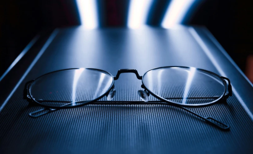 a pair of glasses sitting on top of a table, a picture, blue light, looking straight, close up to the screen, multiple stories