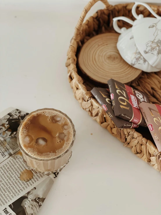 a basket sitting on top of a table next to a cup of coffee, a picture, trending on pexels, jakarta, brown palette, milk, gif