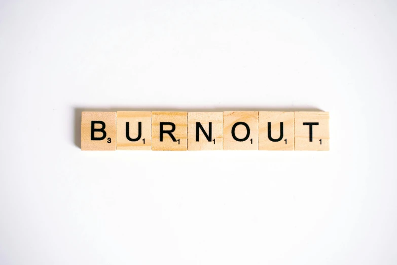 a wooden block with the word burnout written on it, by Rodney Joseph Burn, trending on unsplash, bauhaus, with a white background, square, numerous fires, relaxed posture