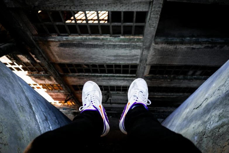 a person standing on top of a metal pipe, inspired by Jordan Grimmer, pexels contest winner, graffiti, nike air max, white and purple, high angle vertical, white shoes