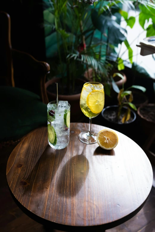 two drinks sitting on top of a wooden table, splento, lemonlight, medium angle, greens)