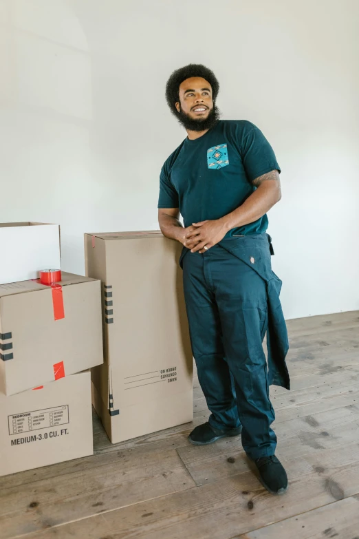 a man standing next to a pile of boxes, profile image, riyahd cassiem, indoor picture, full body hero