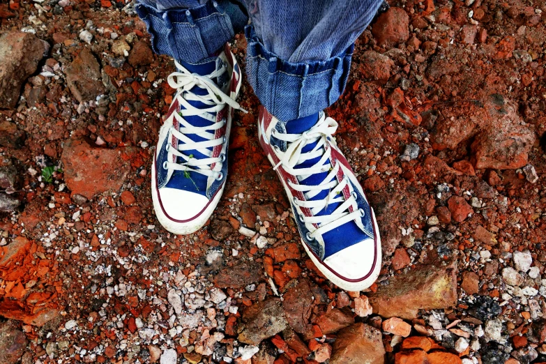 a person standing on top of a rocky ground, by Pamela Ascherson, pexels, sots art, converse, blue and red two - tone, !!highly detailed!!, blue - print