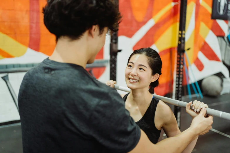 a woman holding a baseball bat next to a man, by Reuben Tam, pexels contest winner, shin hanga, local gym, smiling at each other, lachlan bailey, profile image