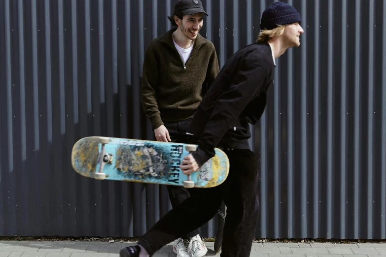 a man and a woman walking with a skateboard, a picture, unsplash, realism, with black beanie on head, two young men, arney freytag, corduroy
