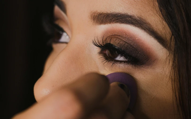 a close up of a person putting a purple object in their eye, trending on pexels, tachisme, dark eyeshadow, contour, warm shading, cardboard