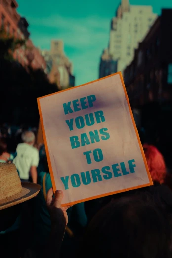 a person holding a sign that says keep your bans to yourself, an album cover, unsplash, renaissance, trans rights, bandoliers, thumbnail, lomography photo
