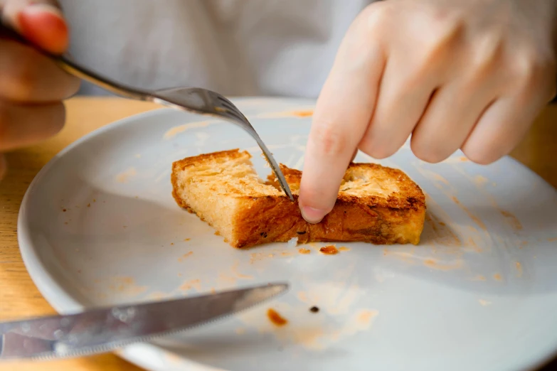 a person cutting a piece of bread on a plate, by Julia Pishtar, squashed, crispy, no text, fork