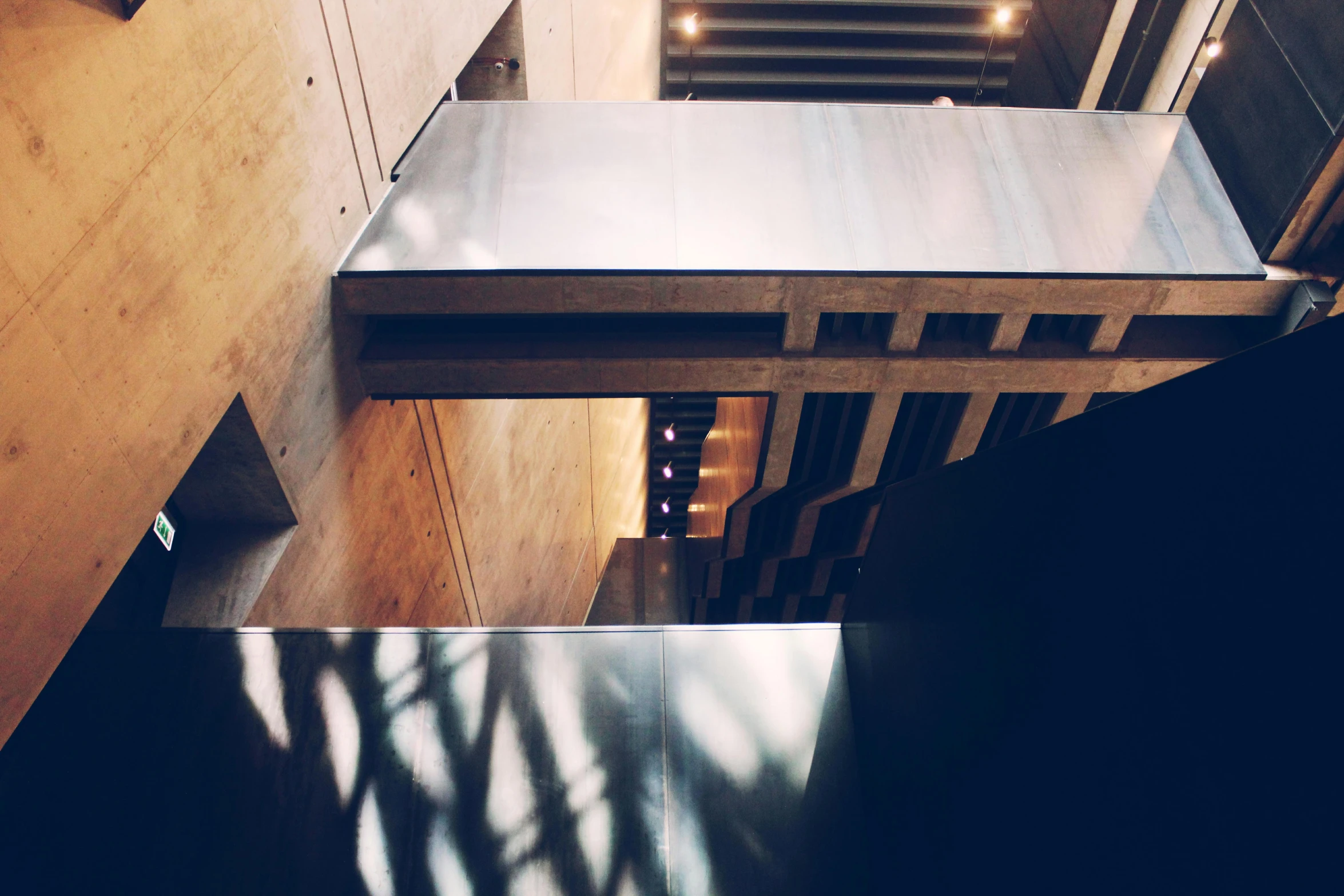 an overhead view of a staircase in a building, inspired by Peter Zumthor, unsplash, light and space, evening lighting, photo on iphone, low-angle, dusty library